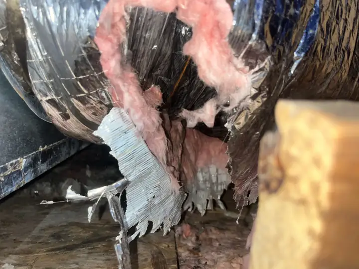 Ripped flex duct with exposed insulation in a hot attic, Slidell