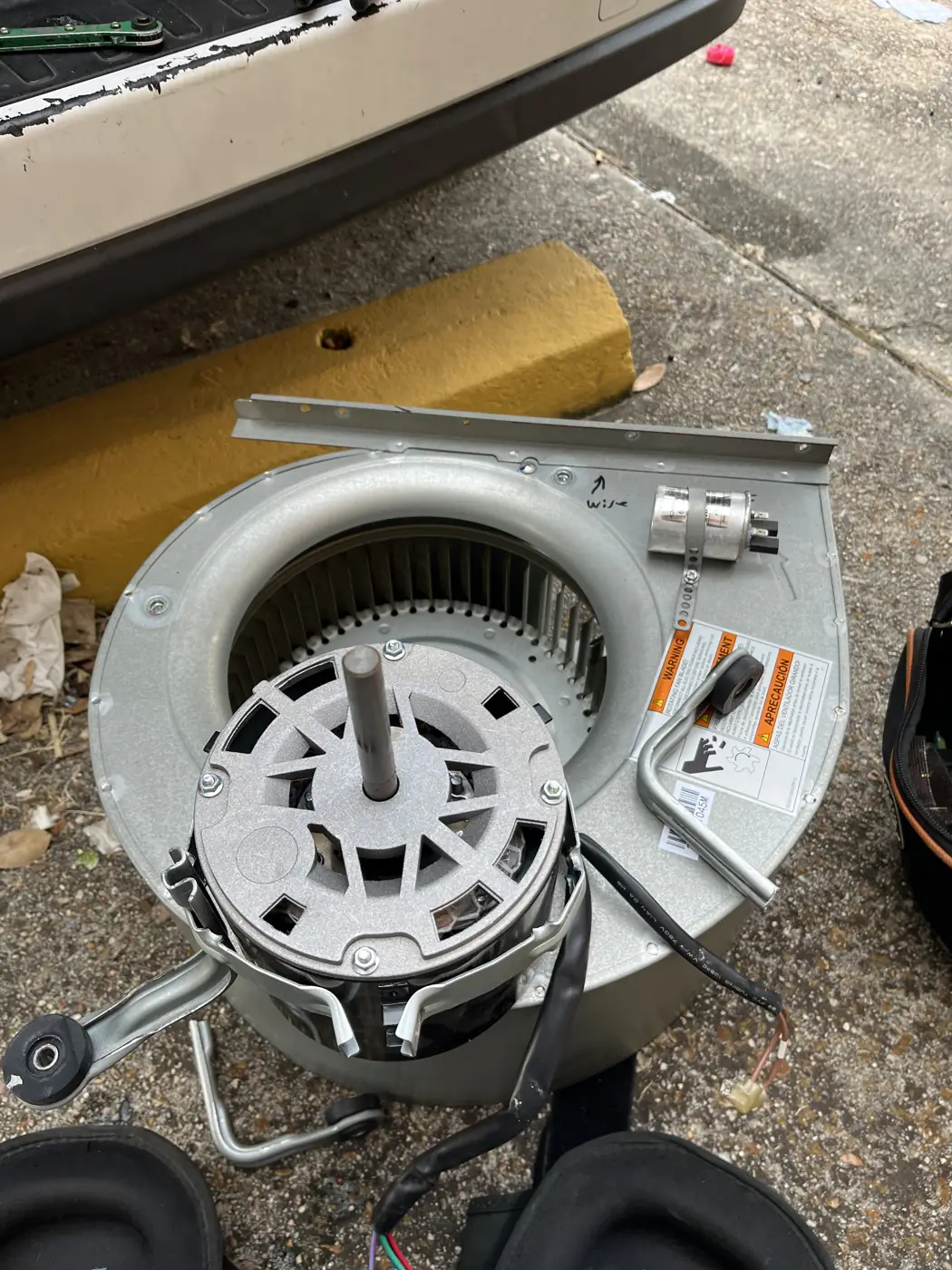 Blower wheel and motor removed from an air handler for replacement