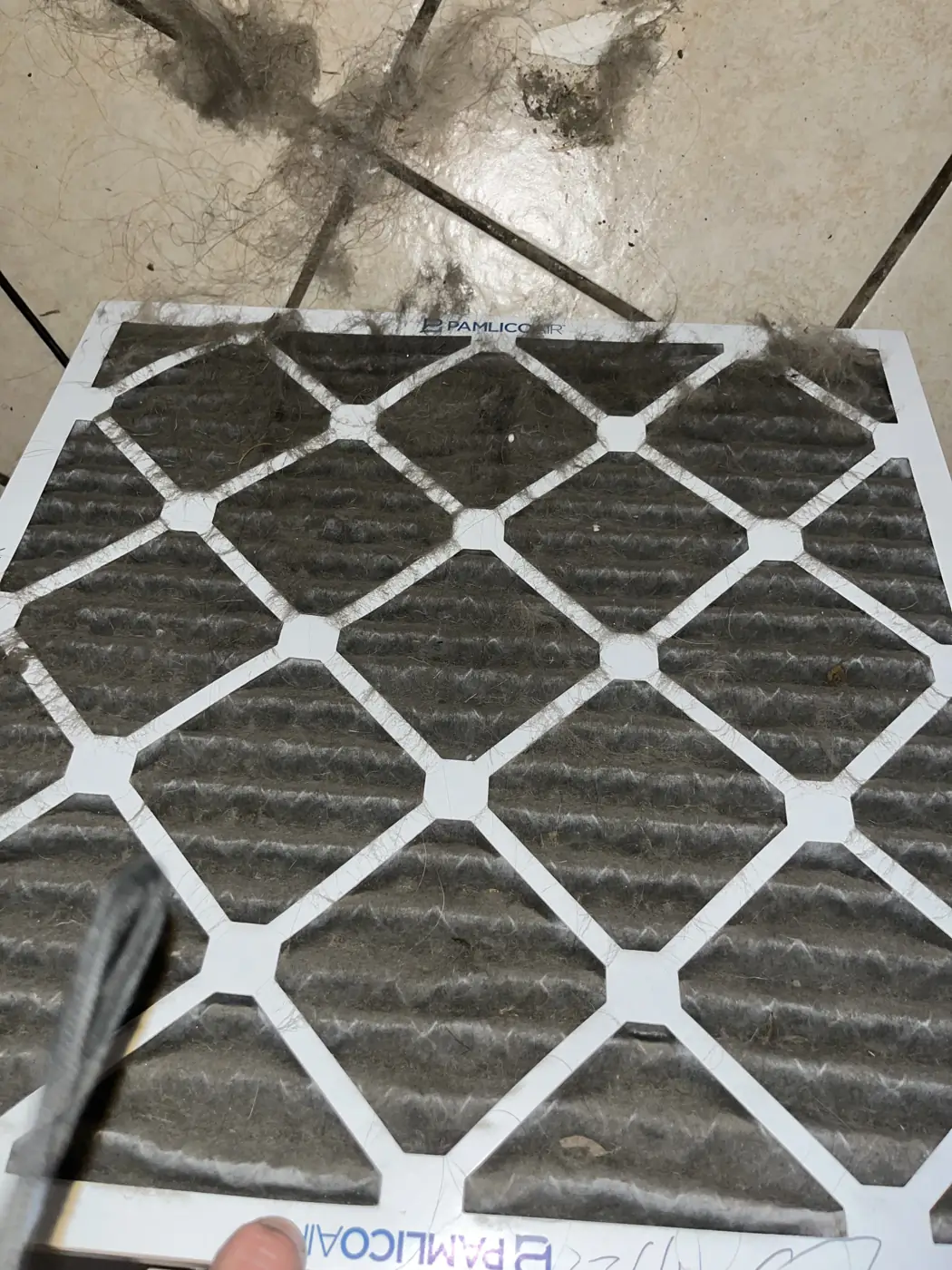Air filter caked gray with dust
