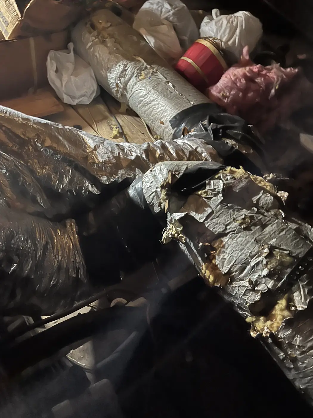 Ripped flex duct jacket with exposed insulation in an attic, Kenner